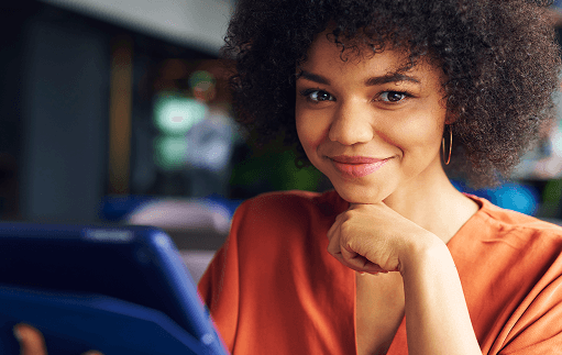 Mulher de negocios com um tablet na mão e olhando para a camêra.